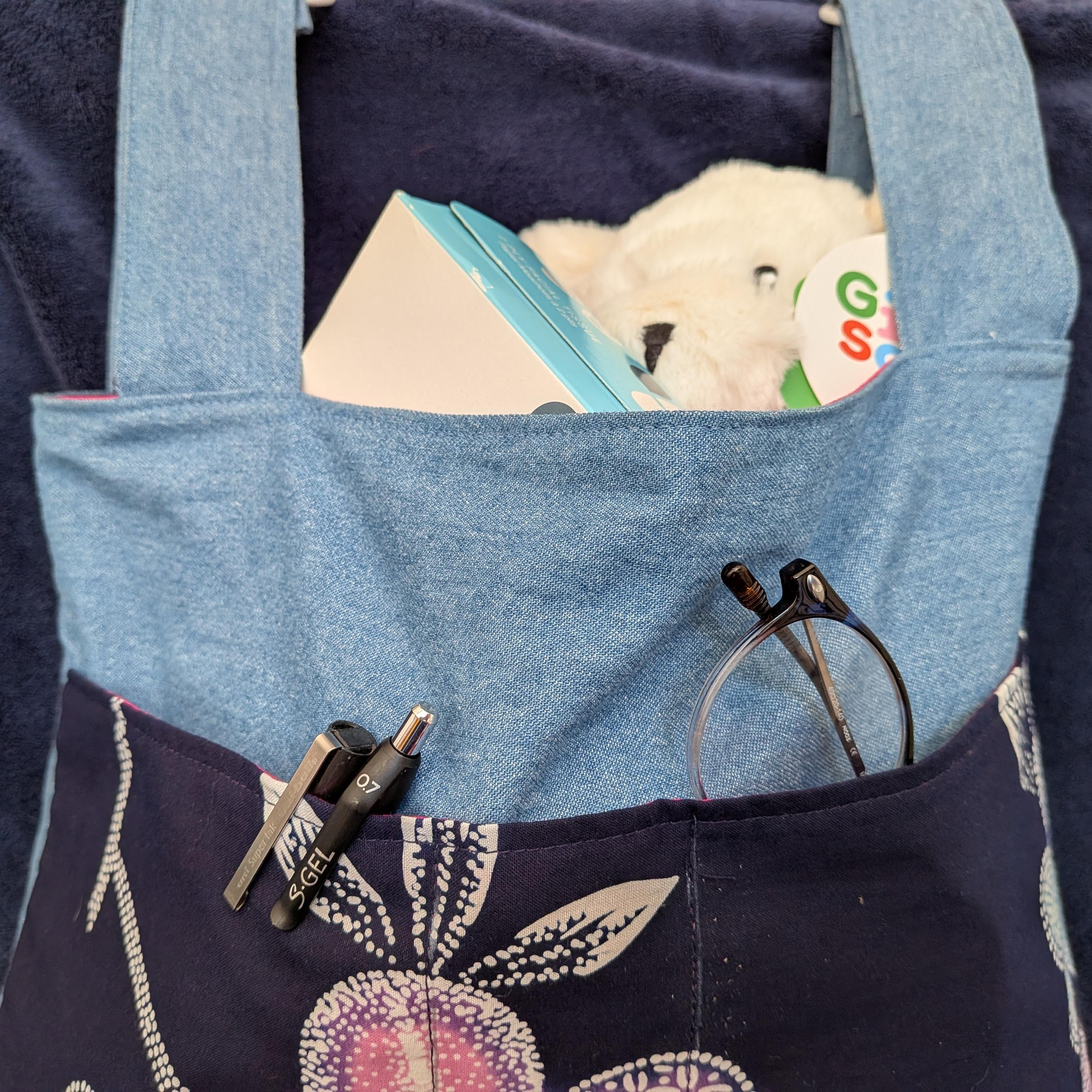 Example of a bag filled with items like pens, reading glasses, facial tissue box, and stuffed bear.